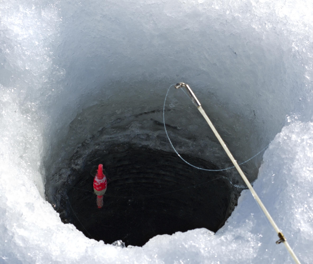 Fishing pole and floating bob in an icehole near Gunflint Trail, Minnesota.