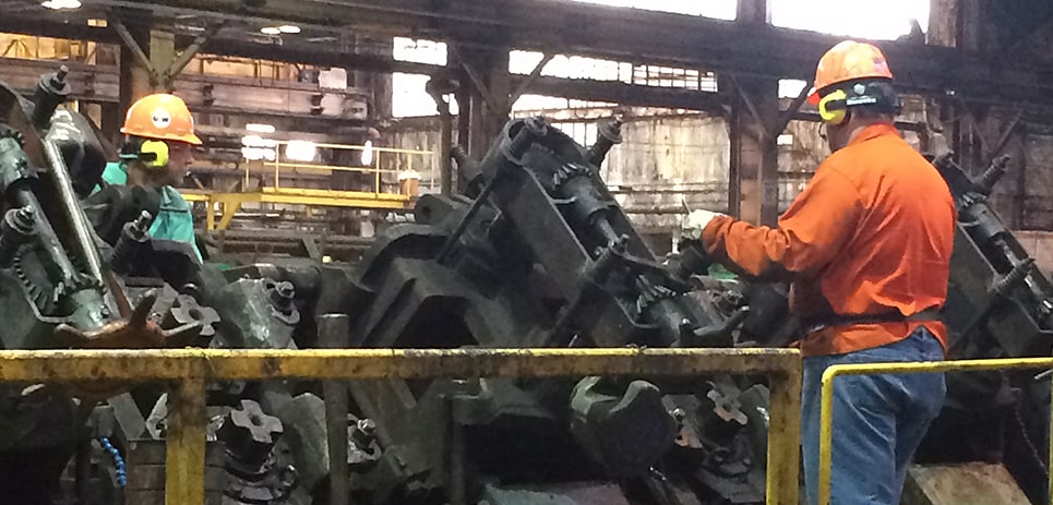 Workers in a steel manufacturing plant using Sonetics Wireless Headsets.