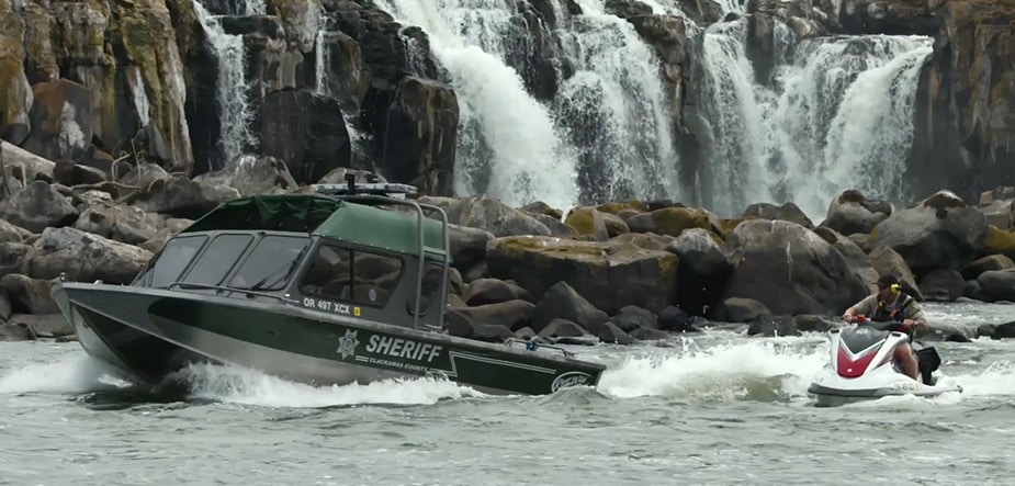 Team members communicate between small watercarft while patroling the river in front of Willamette Falls.
