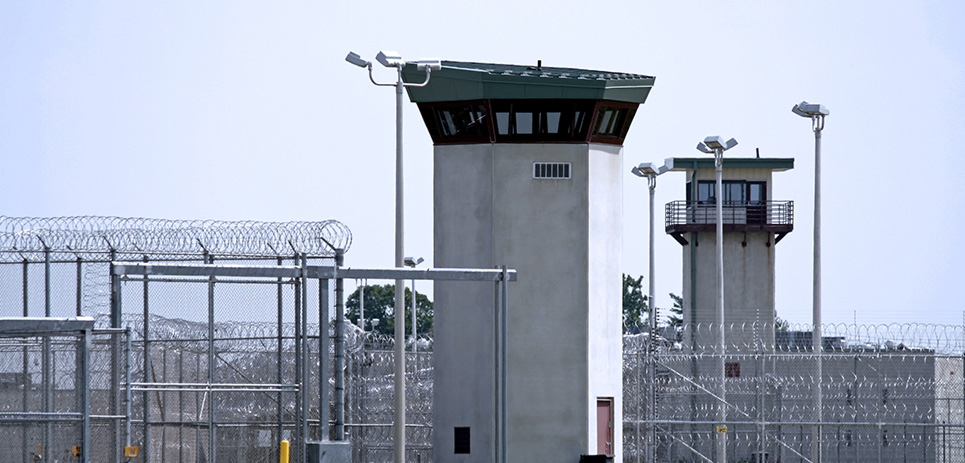 Perimeter fencing and guard towers overlooking a prison.
