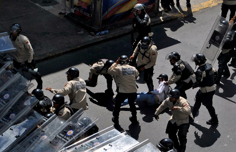 Members of the Venesuelan National Police arrest a student during an opposition demonstration against the government of Venezuelan President Nicolas Maduro, in Caracas on February 12, 2014.